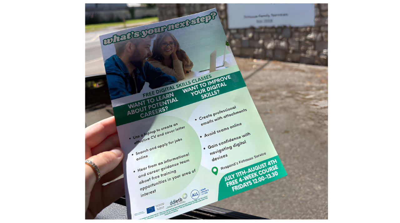 A hand holds a flyer for free digital skills classes, covering CV creation, job searching, email composing, and scam avoidance. Dates: July 11 - August 4.